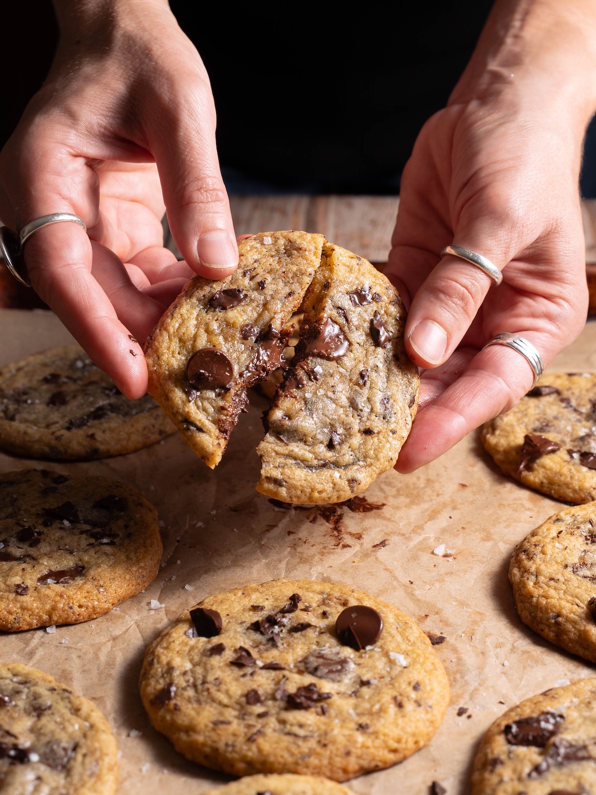 Breaking a sourdough chocolate chip cookie in half