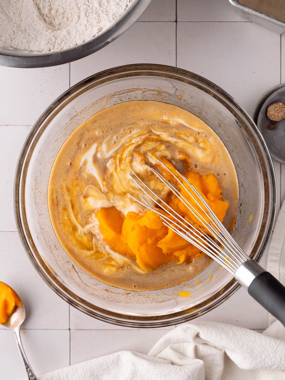 Whisking together pumpkin puree, sourdough discard, and other wet ingredients for a quick bread