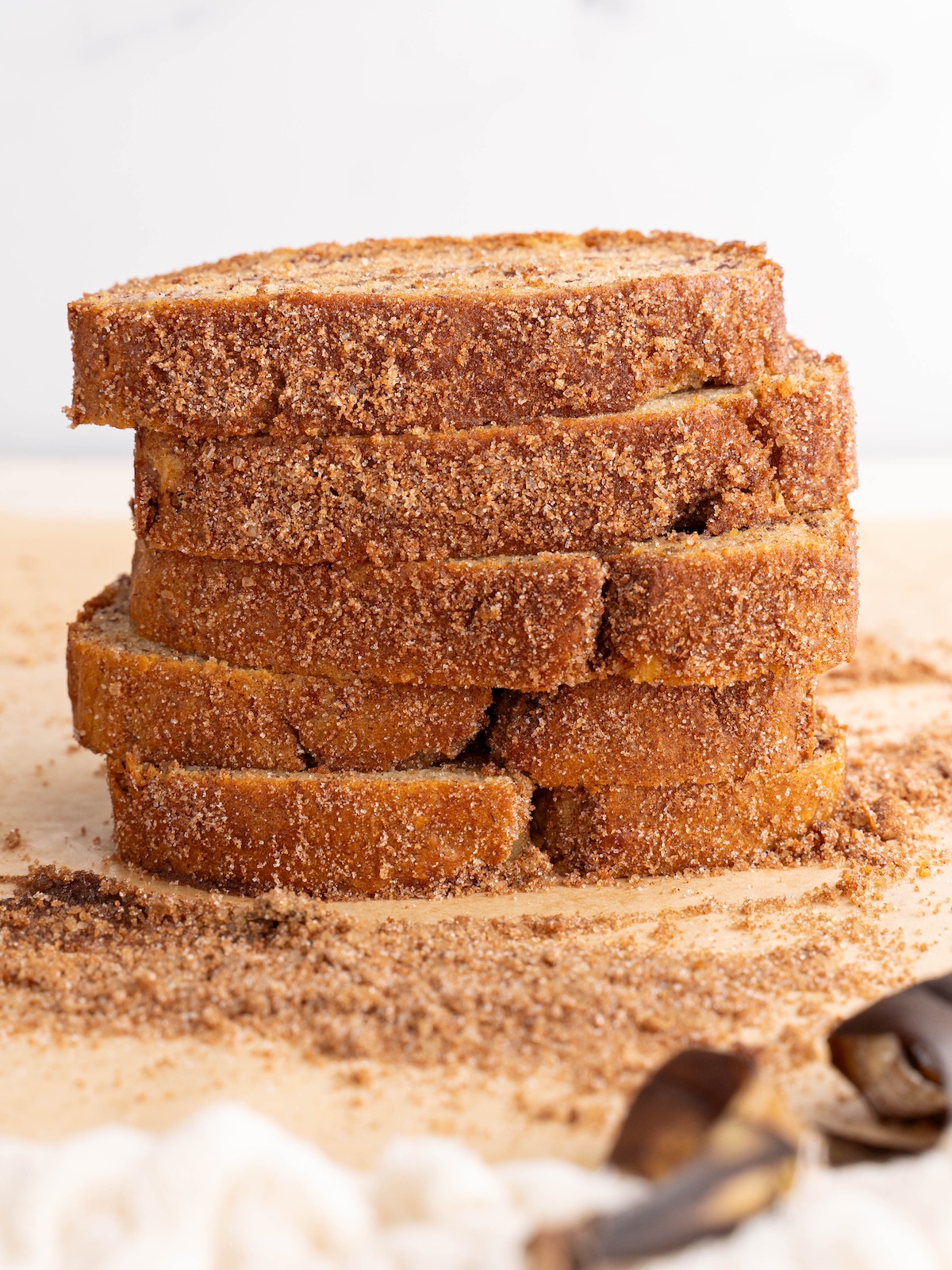 Slices of banana bread stacked to show crunchy cinnamon sugar crust