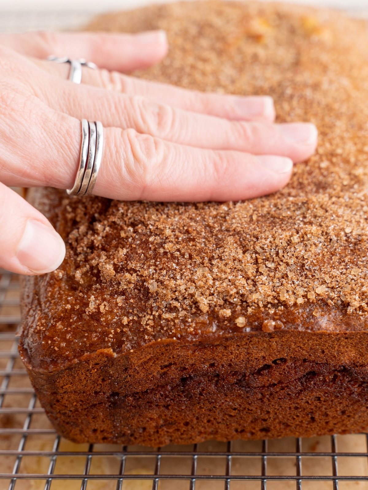 Rubbing cinnamon sugar into crust of banana bread