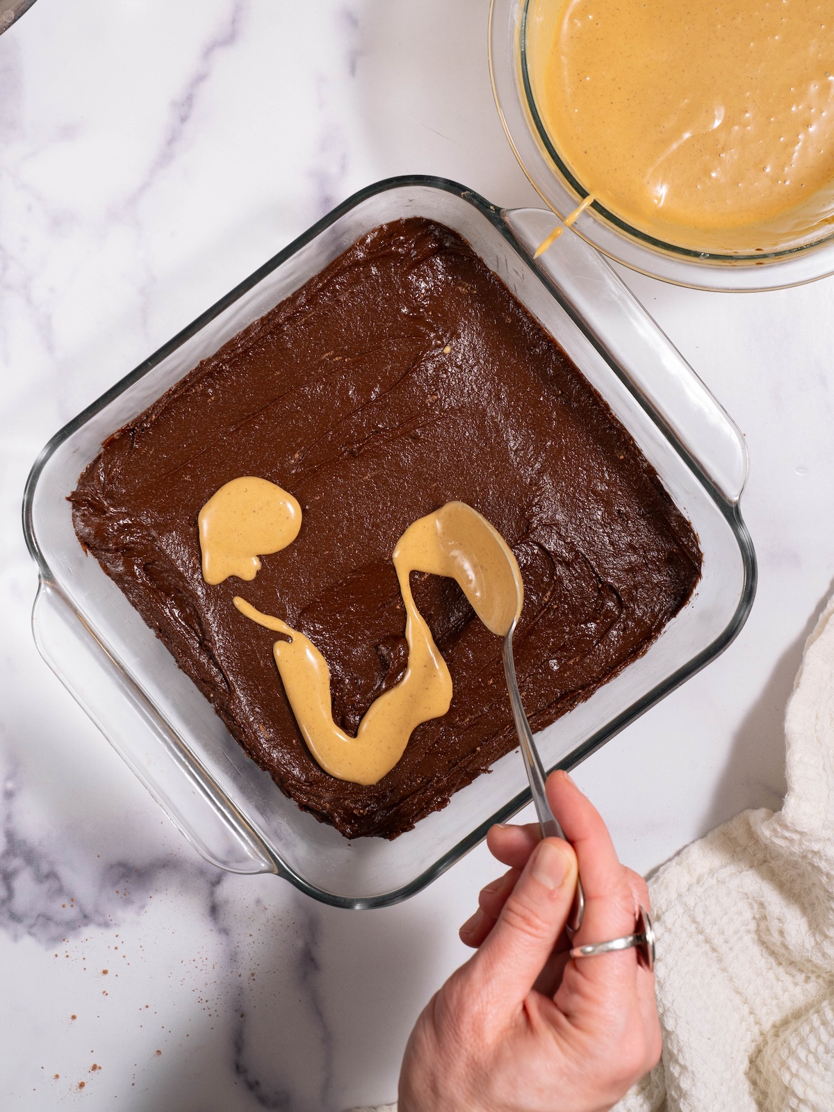 Dolloping gingerbread cream cheese mixture onto brownie batter