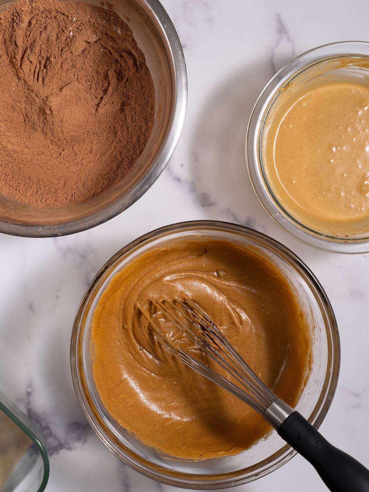 Three bowls full of ingredients to make brownies