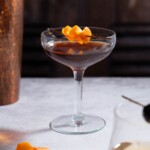 A Nocino Black Manhattan cocktail garnished with orange peel