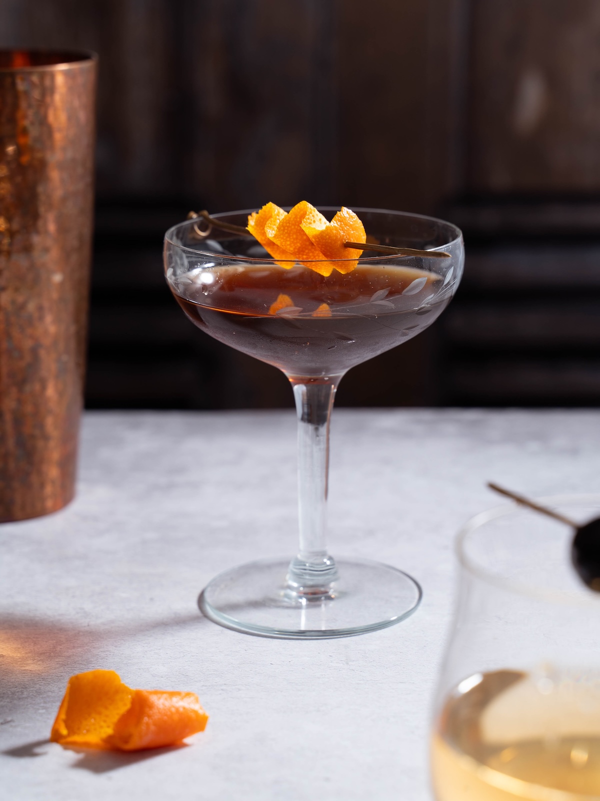 A Nocino Black Manhattan cocktail garnished with orange peel