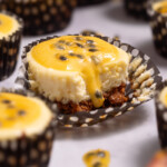A mini passionfruit cheesecake with passionfruit curd dripping down the side