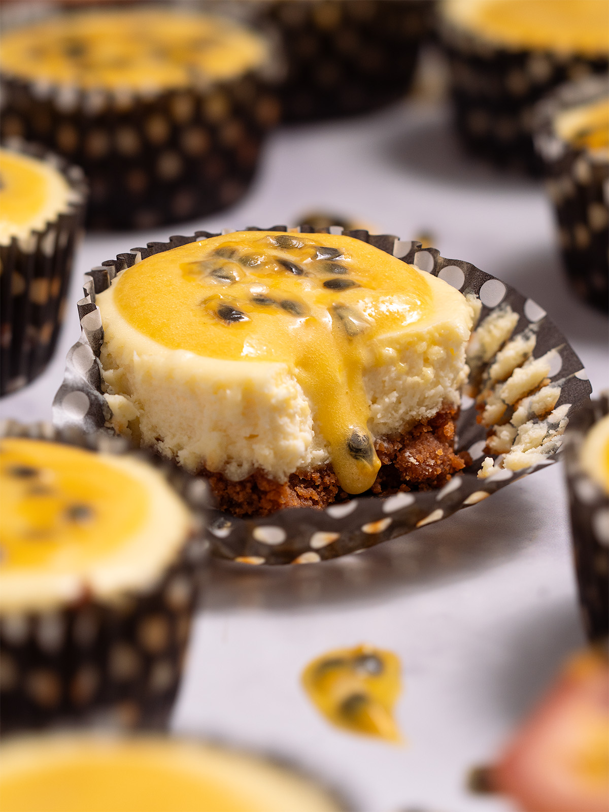 A mini passionfruit cheesecake with passionfruit curd dripping down the side