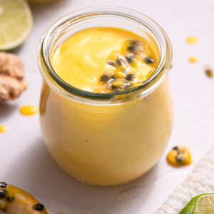 A jar of passionfruit ginger curd with passionfruit seeds on top