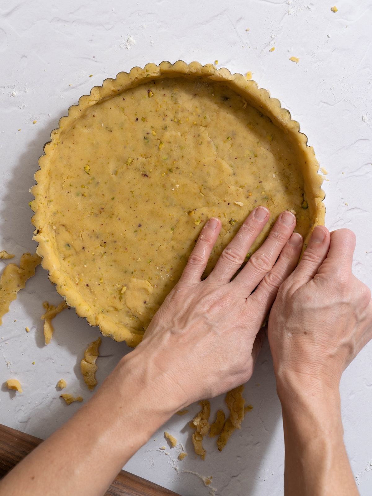 Removing excess dough from the edges of a tart crust