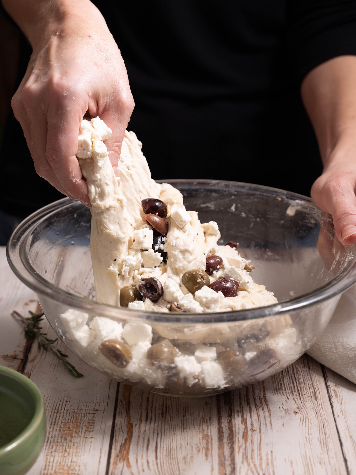 Folding olives and feta into sourdough bread