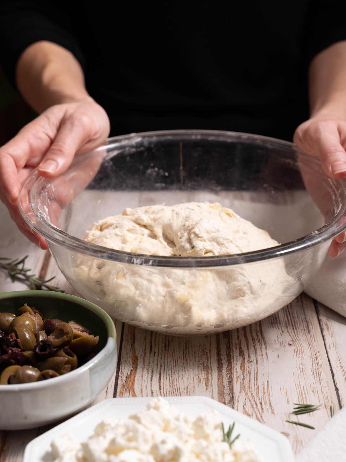 A bowl of sourdough, olives, and feta