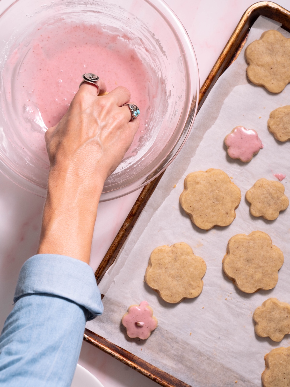 Dipping magnolia cookies into blood orange glaze