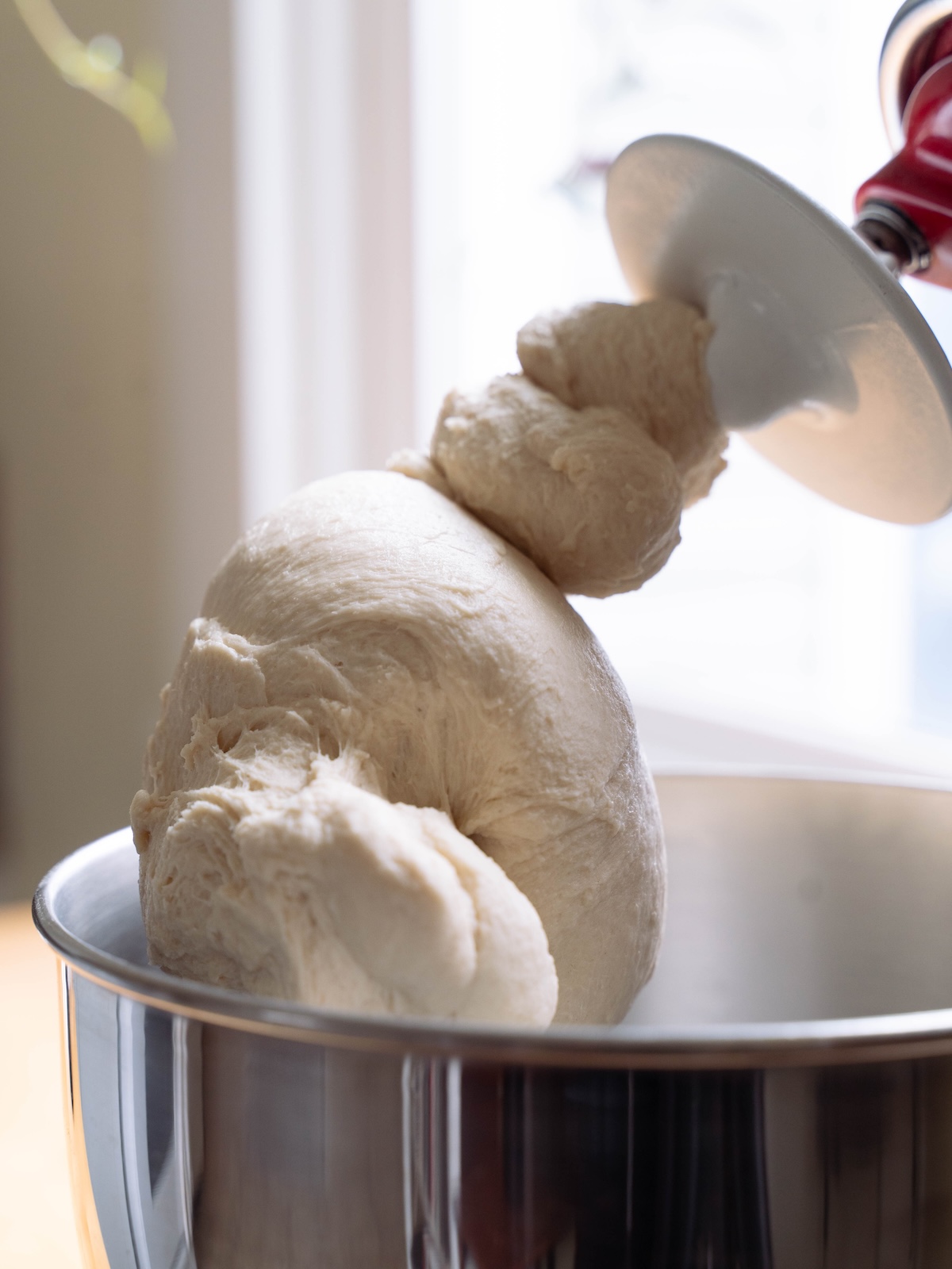 Bread dough oh the hook attachment of a Kitchenaid stand mixer