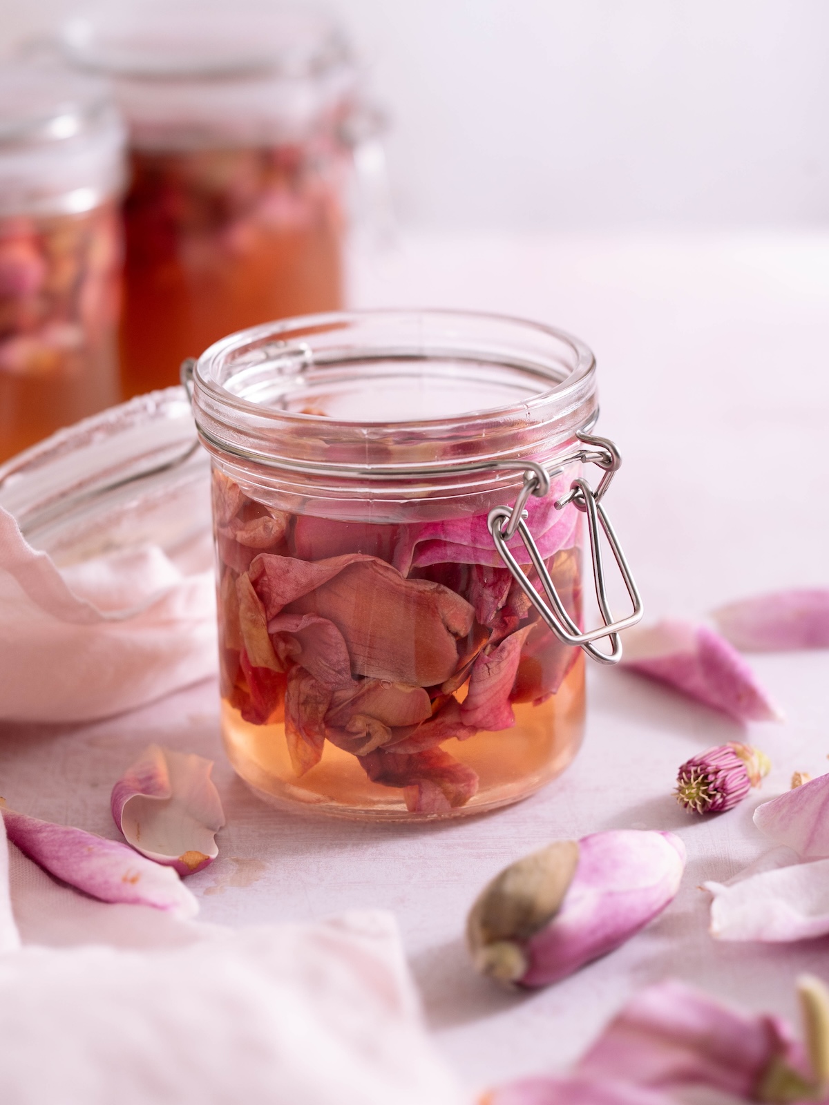 An open jar of magnolia flowers in brining liquid