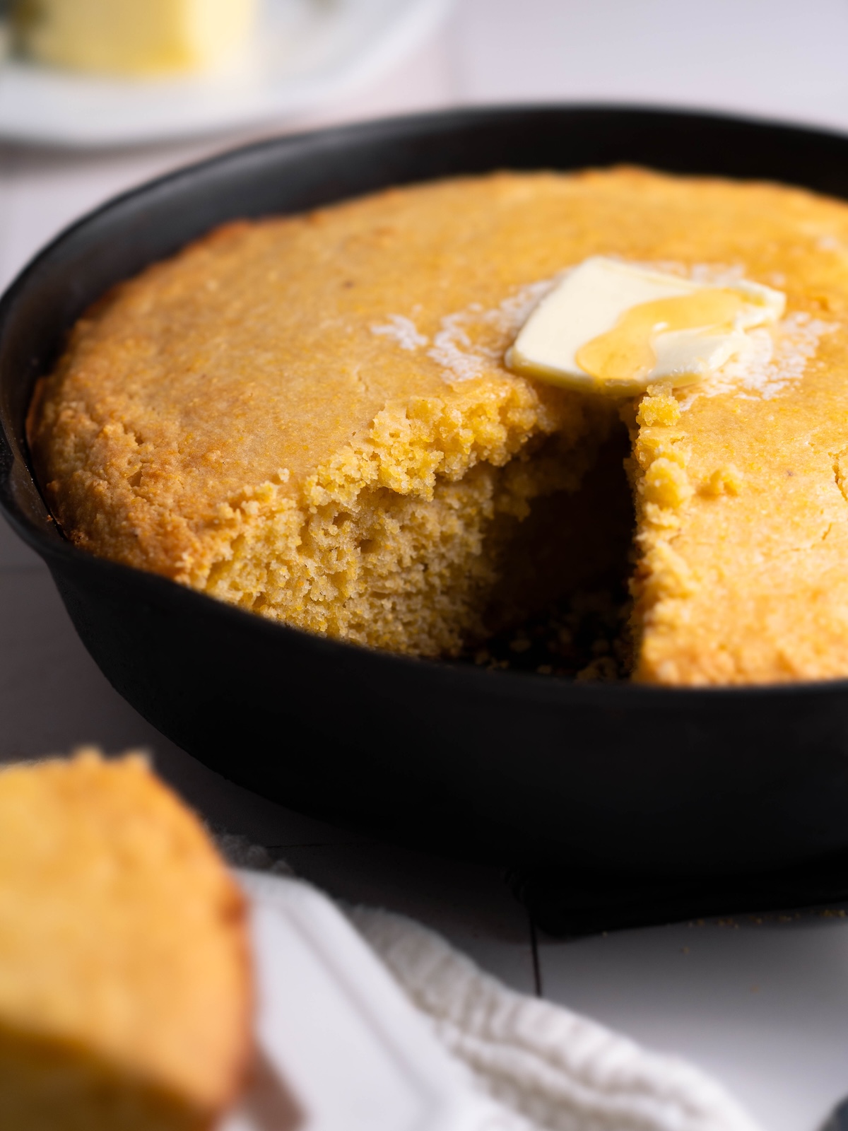 A batch of cornbread with a slice removed