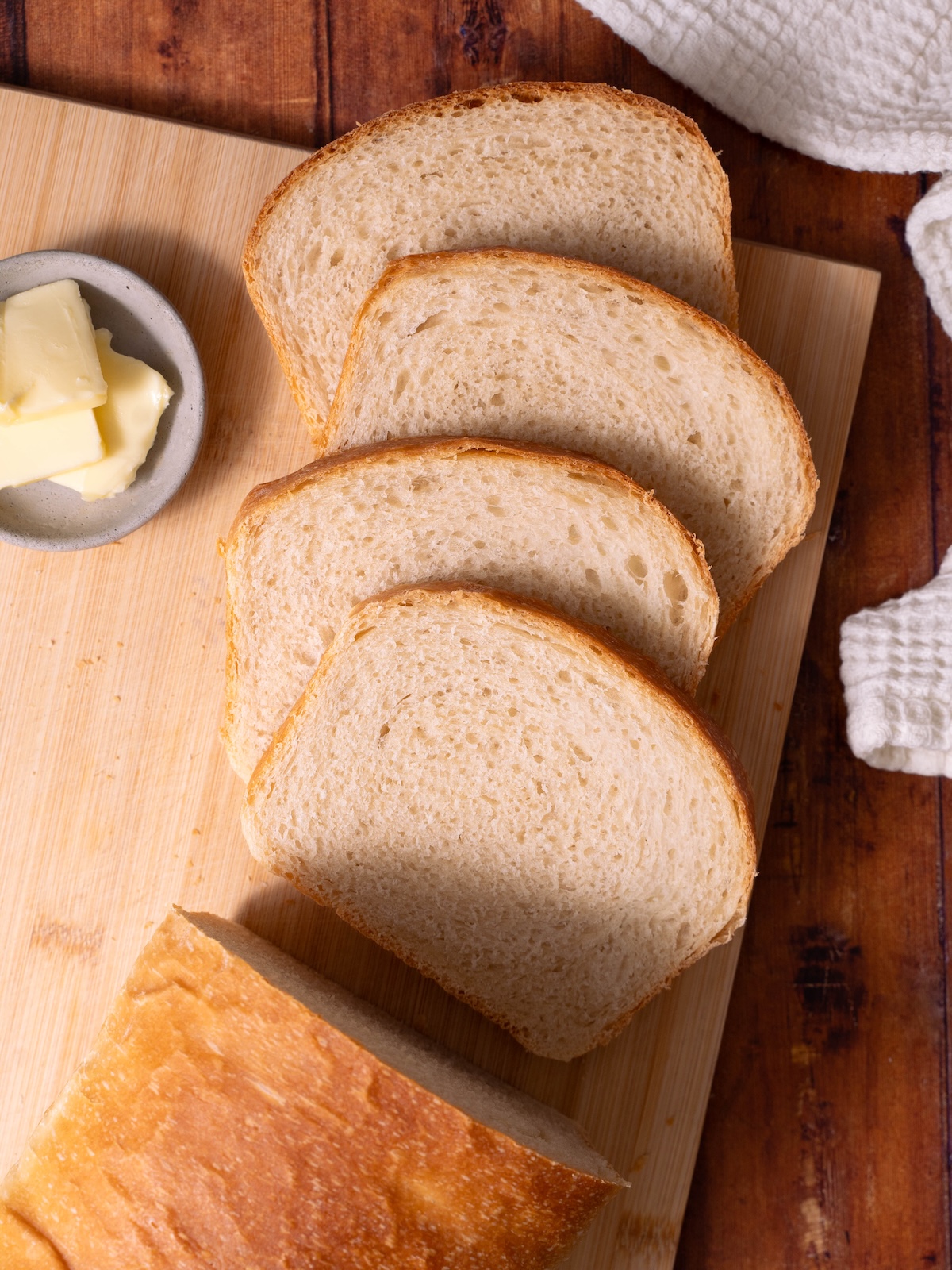 Slices of sourdough sandwich bread fanned out on a cutting board