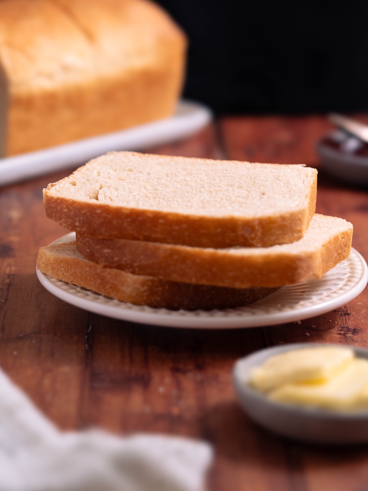 Slices of sourdough sandwich bread stacked on a plate
