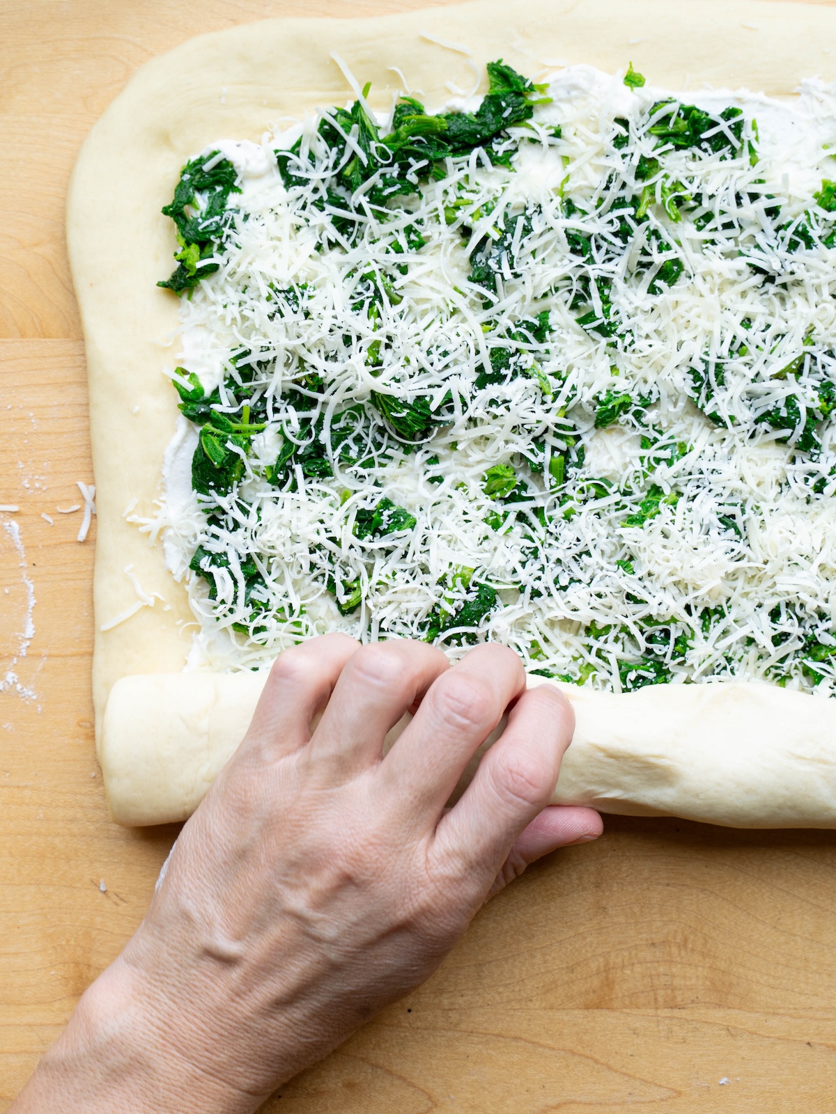 Rolling a savory nettle roll into a log