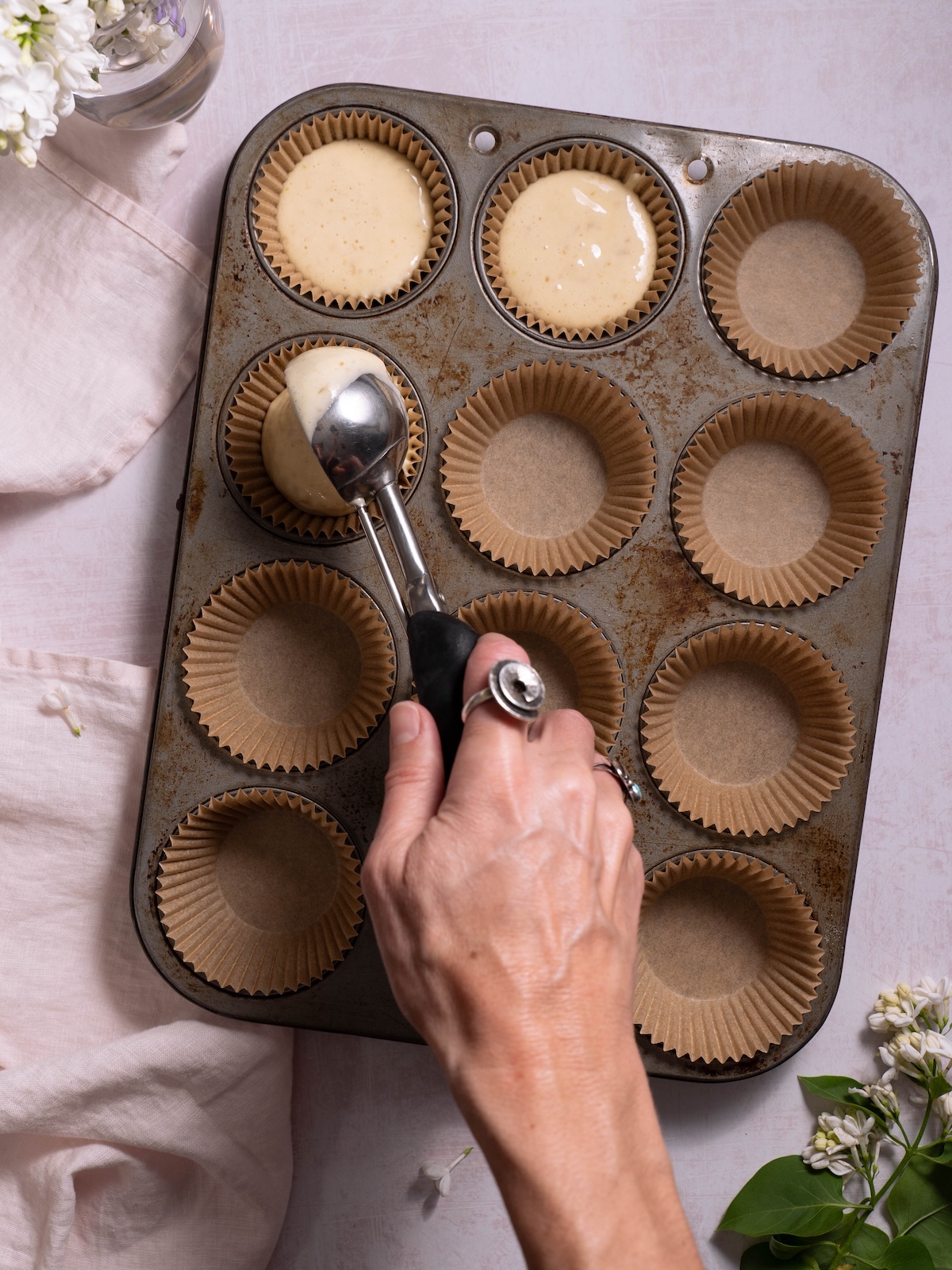 Scooping cupcake batter into a cupcake pan