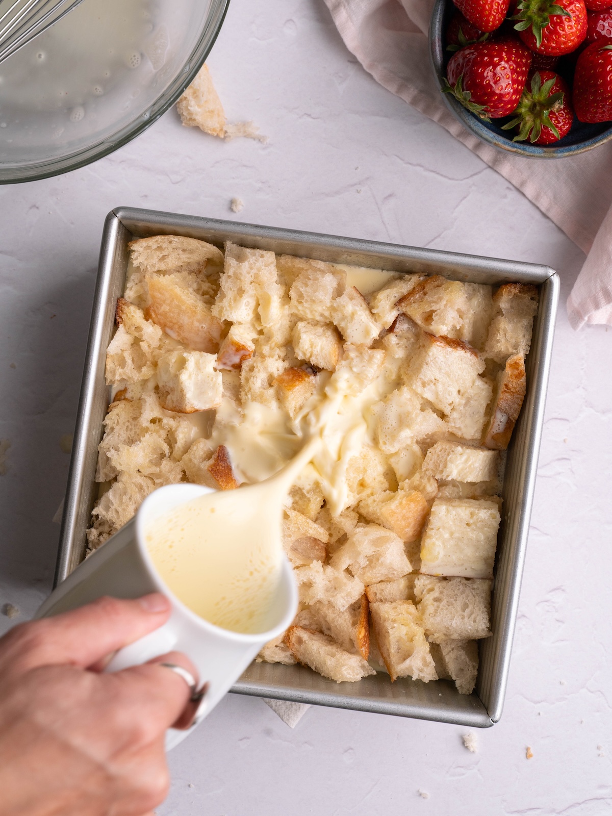 Pouring custard over sourdough bread chunks