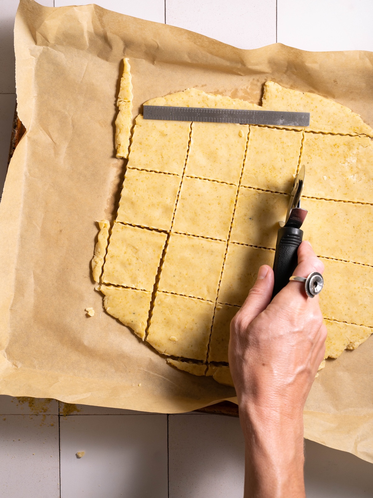Slicing cookie dough with a fluted pastry wheel