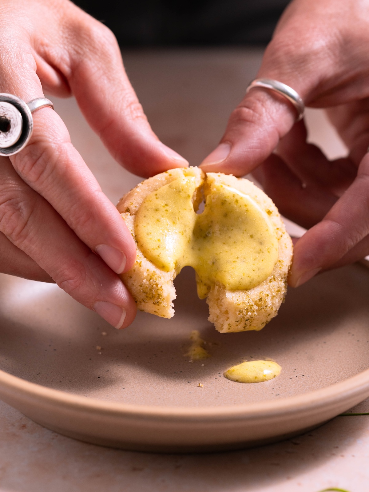 Breaking open a lemon fir tip curd thumbprint cookie