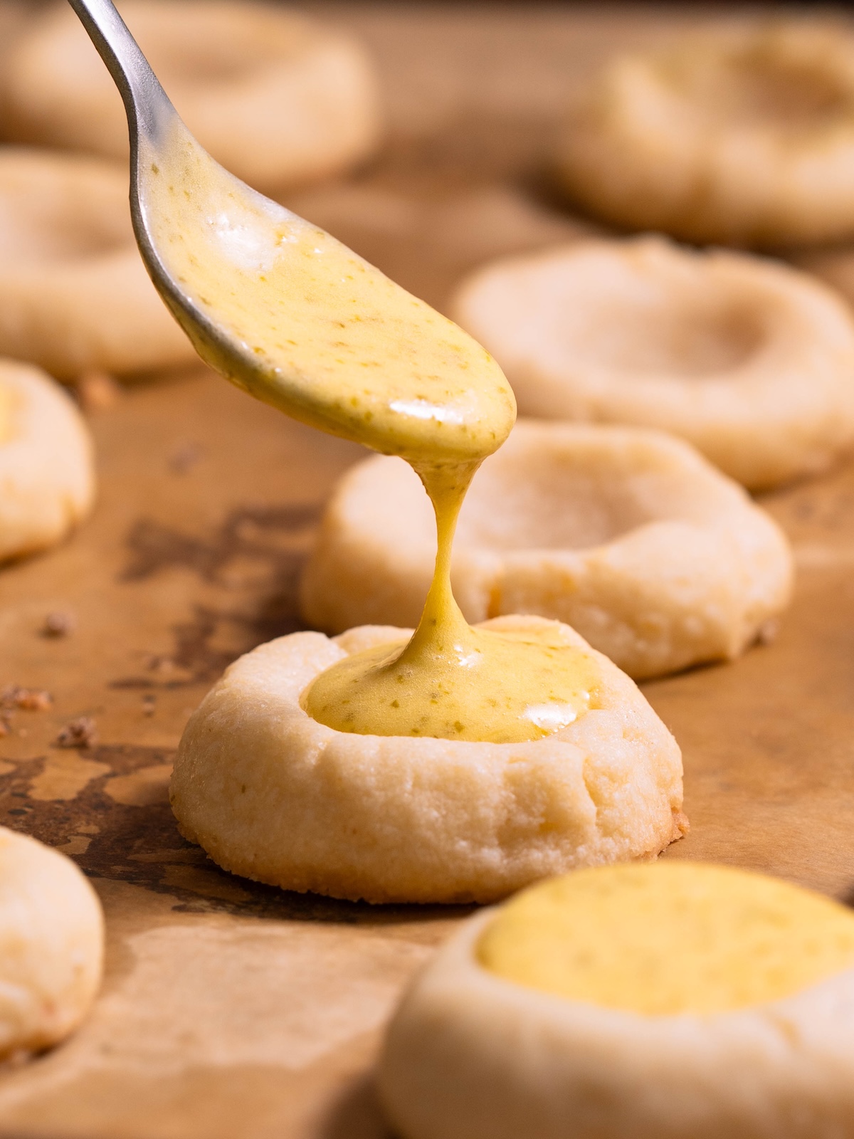 Filling lemon thumbprint cookies with lemon & fir tip curd