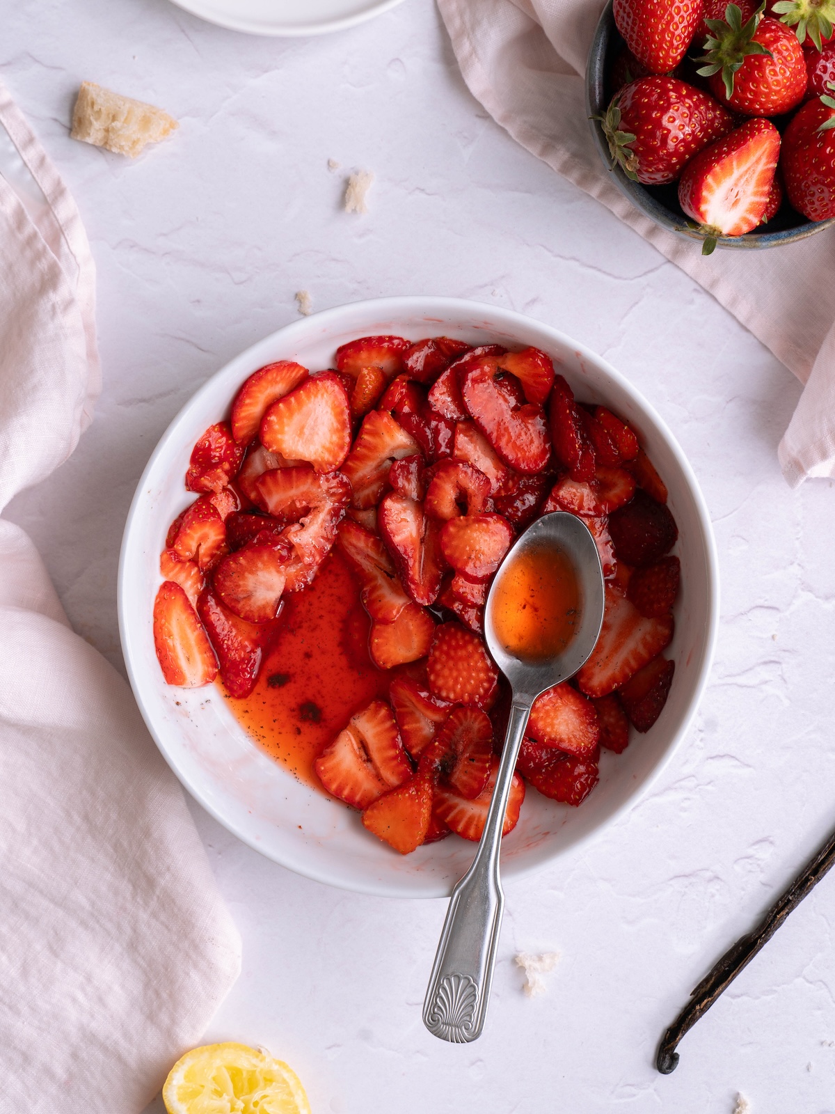 A bowl of fresh strawberries macerating with vanilla bean and sugar