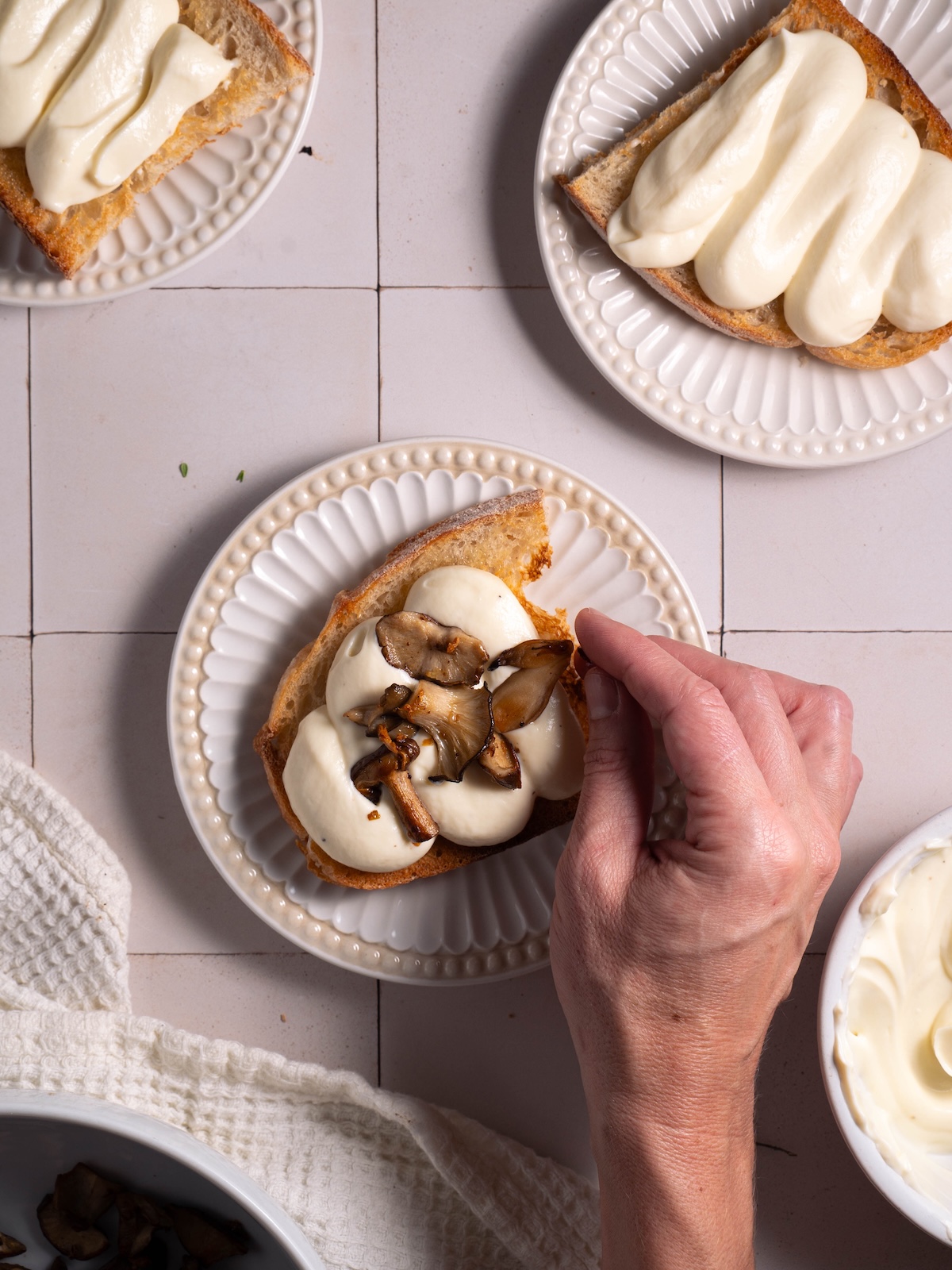 Placing cooked mushrooms on top of savory toast