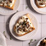 Slices of sourdough topped with whipped ricotta and garlic butter mushrooms