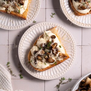Slices of sourdough topped with whipped ricotta and garlic butter mushrooms