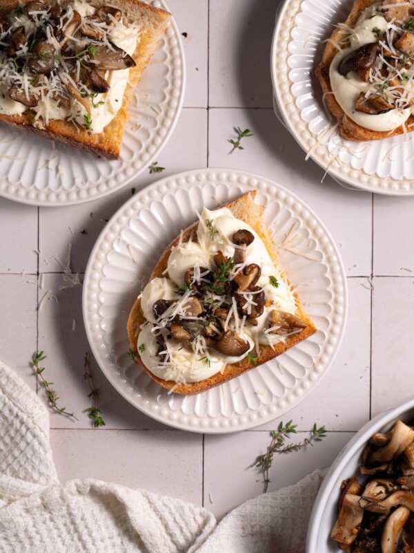Slices of sourdough topped with whipped ricotta and garlic butter mushrooms