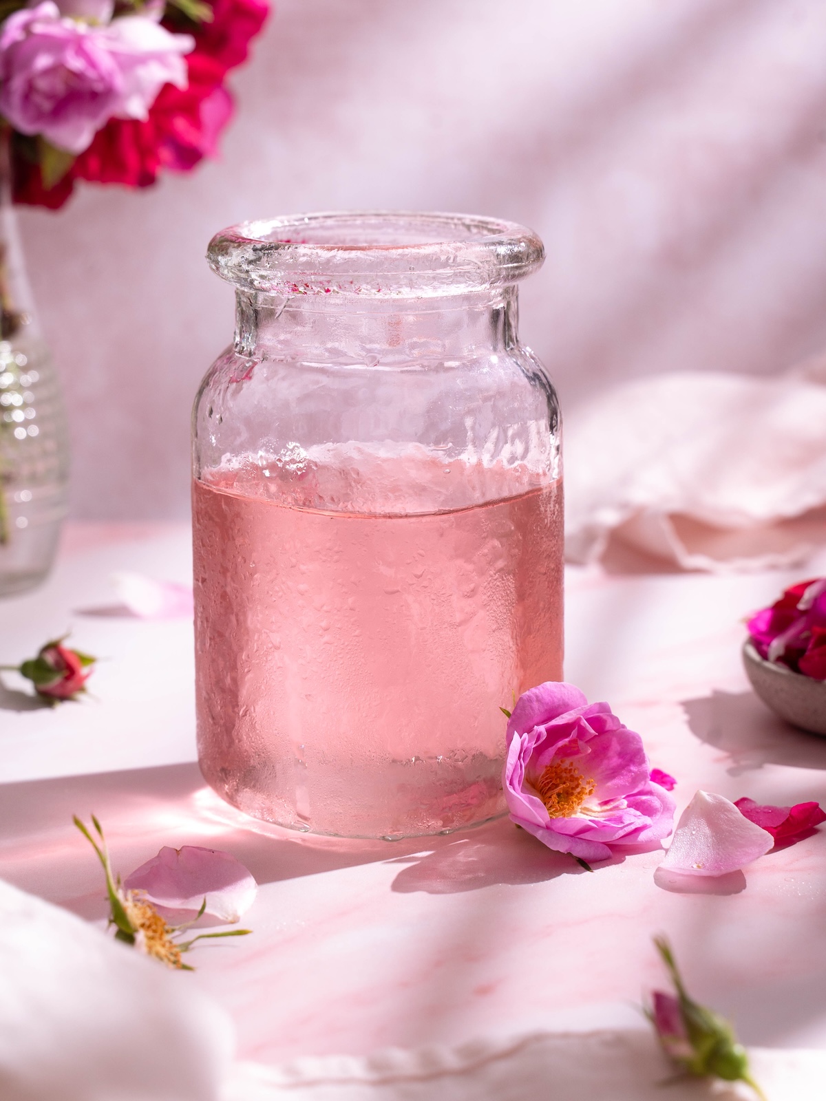 A jar filled with subtly pink homemade rose simple syrup