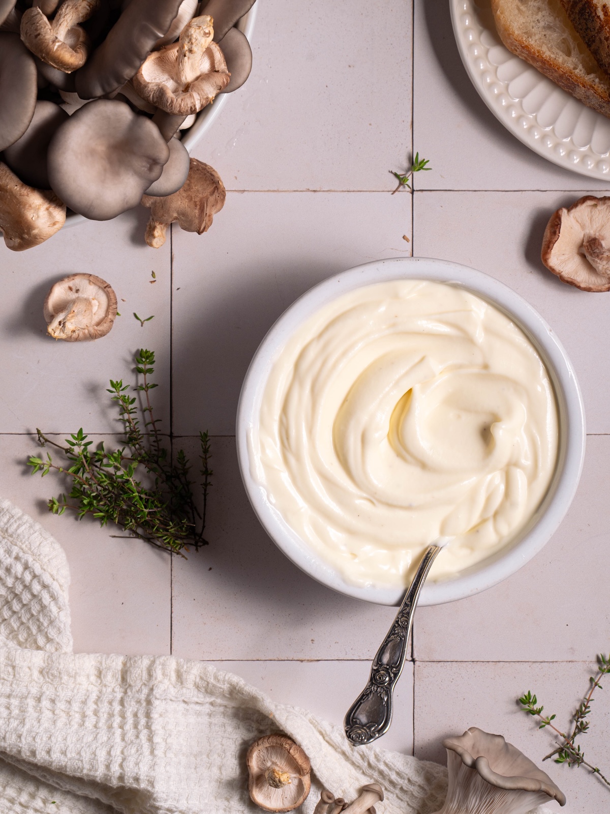 A bowl of whipped ricotta, fresh thyme, and fresh shiitake and oyster mushrooms