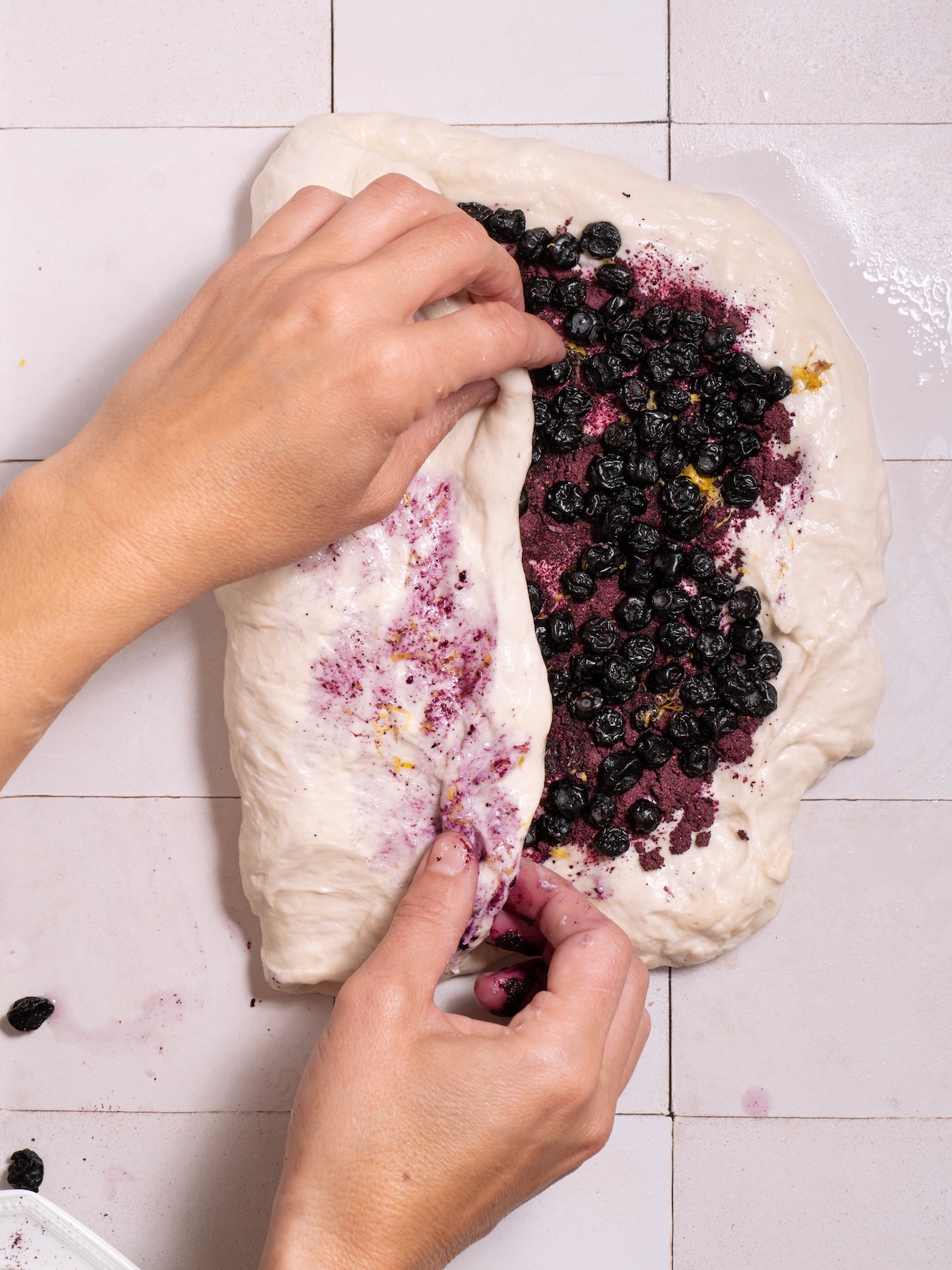 Folding blueberry powder and dried blueberries into sourdough