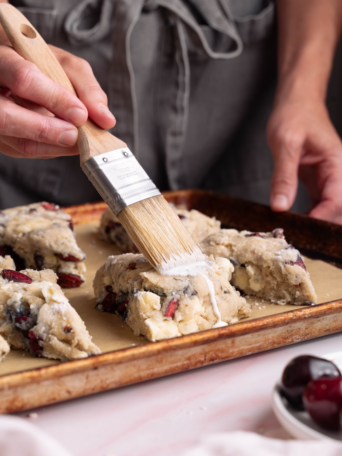 Brushing cherry scones with heavy cream