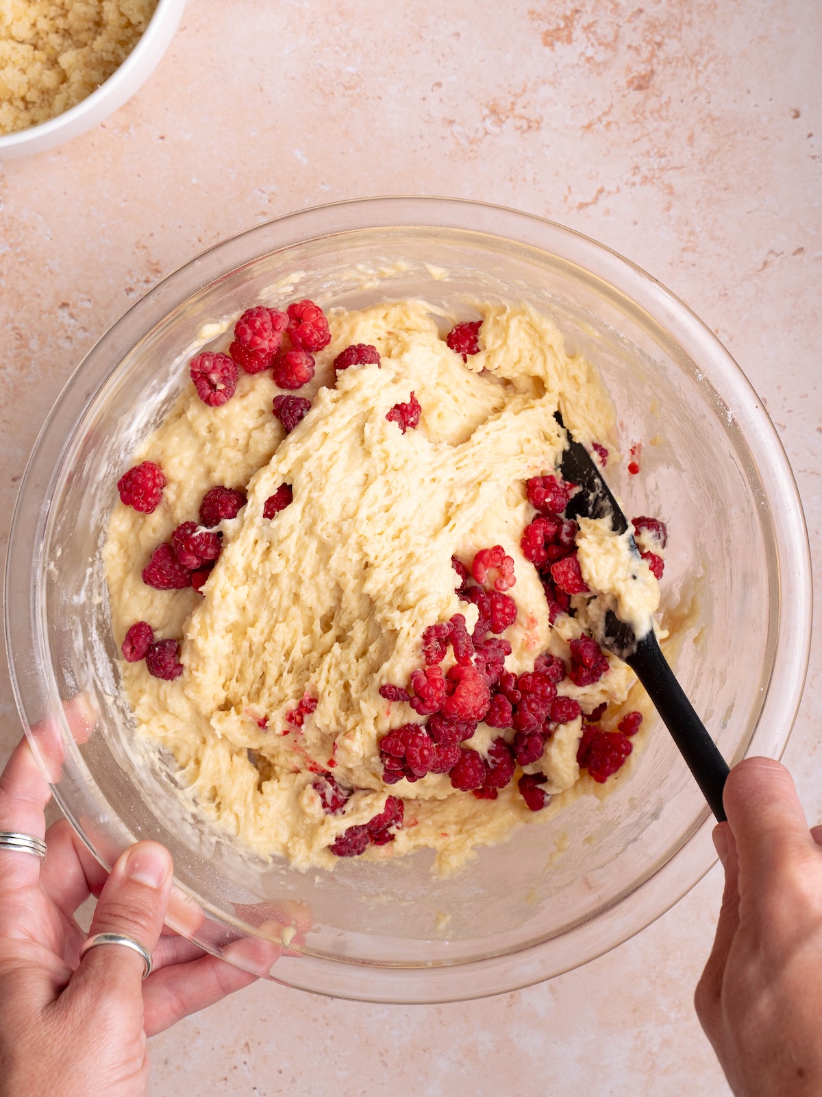 Folding fresh raspberries into muffin batter