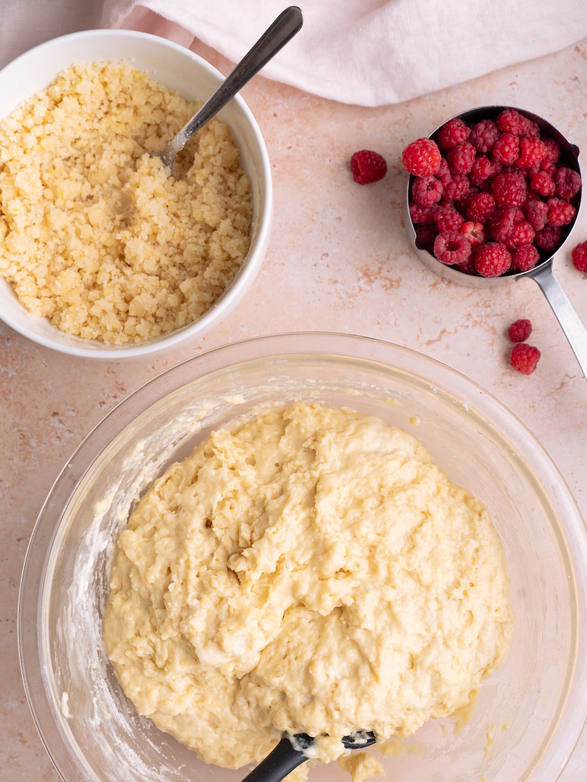 Bowls of muffin batter, lemon streusel, and fresh raspberries
