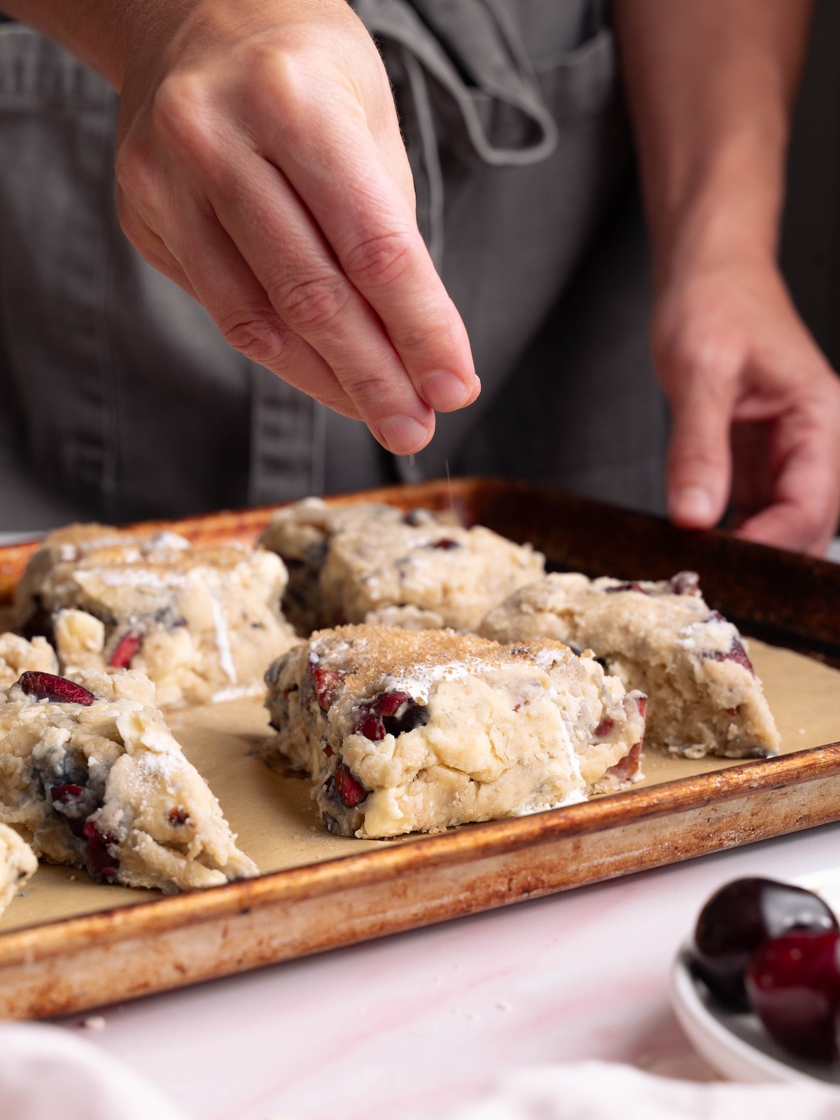 Sprinkling coarse sugar on top of scones