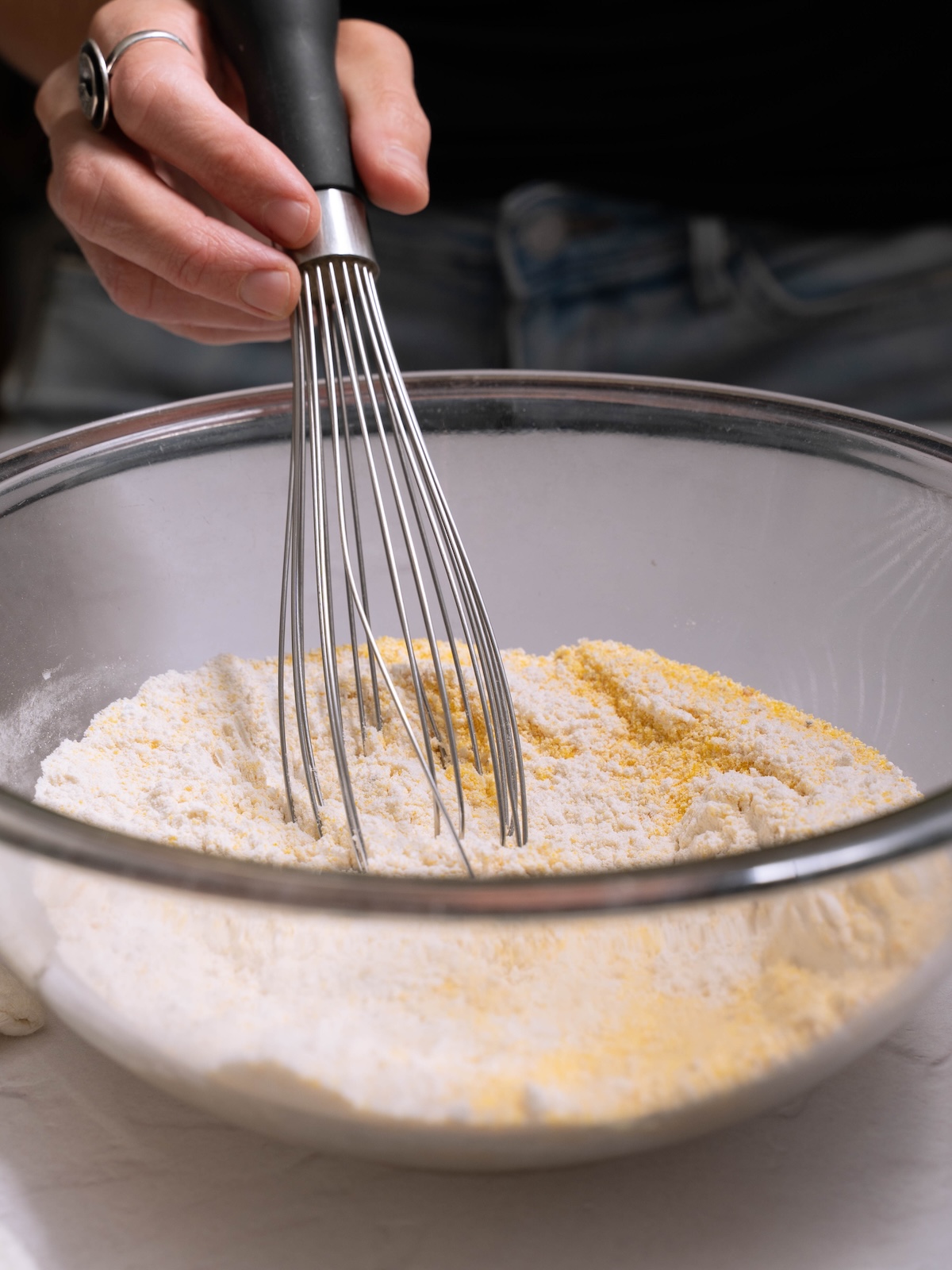 Whisking together flour and cornmeal in a mixing bowl