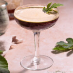 A fig leaf shakerato served in a coupe glass with a tiny fig leaf garnish