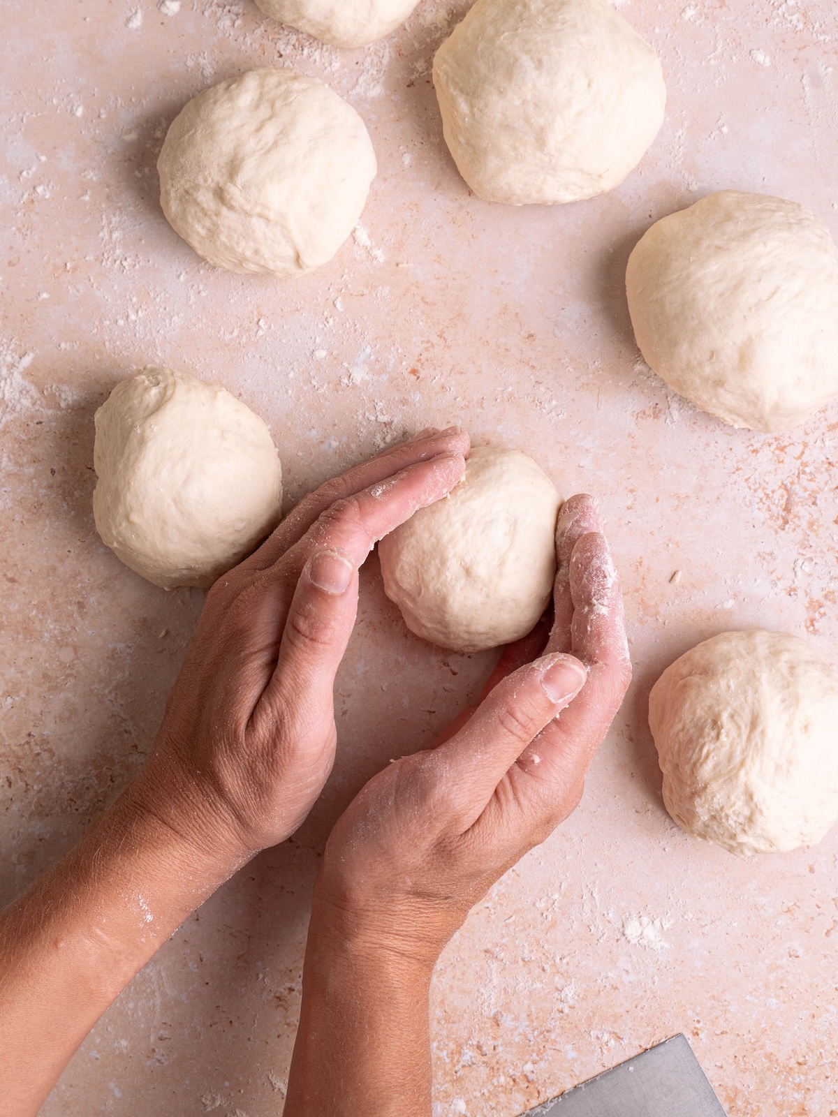 Shaping bread dough into balls by hand