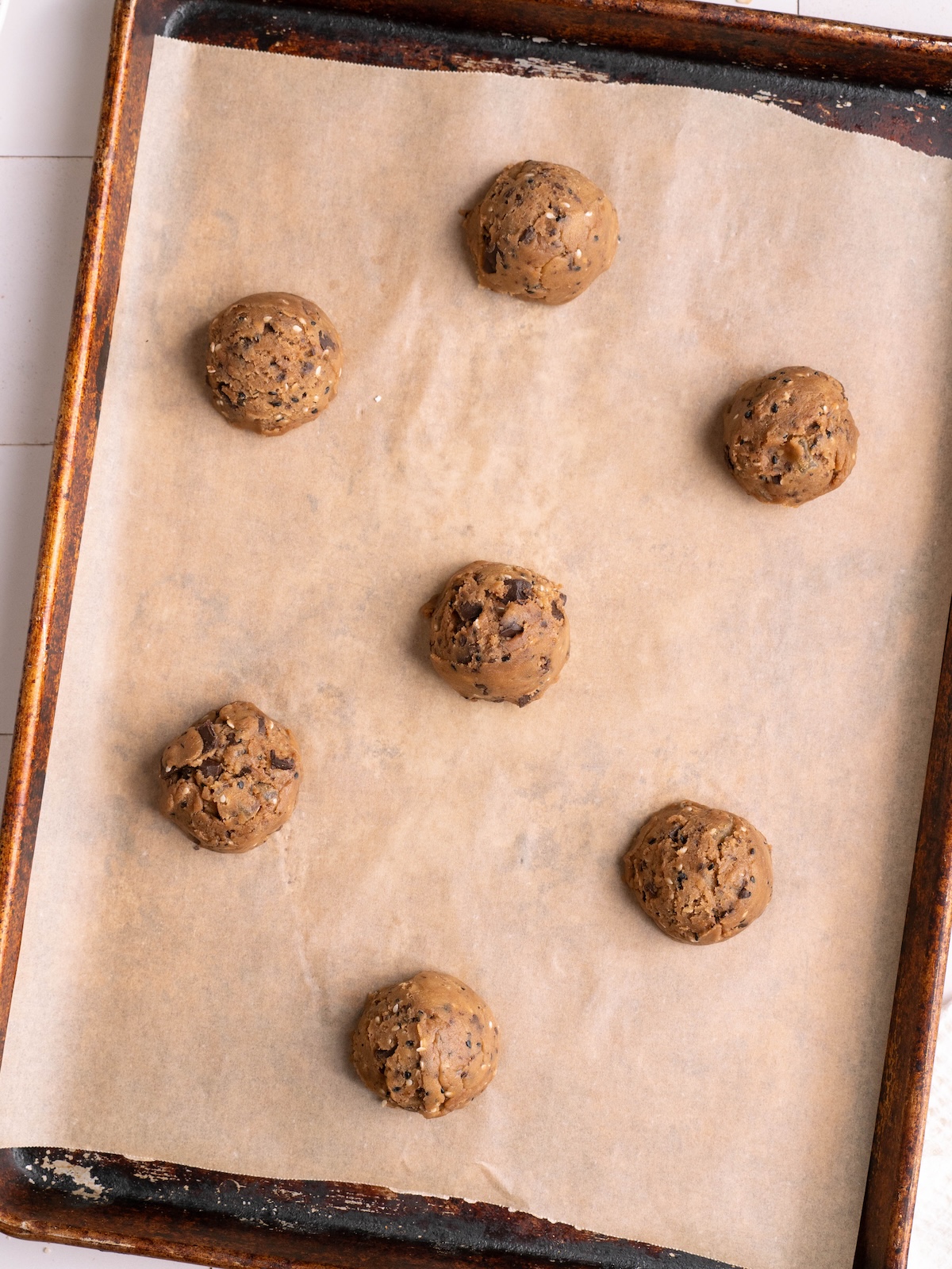 Cookie dough balls on a baking sheet before baking