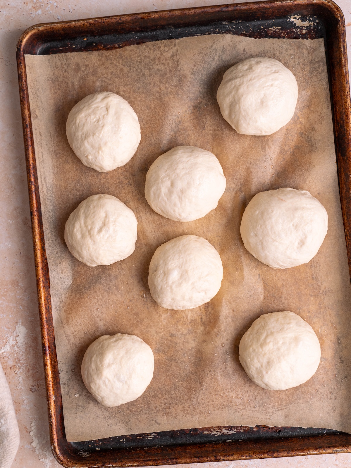 Balls of sourdough naan dough on a baking sheet