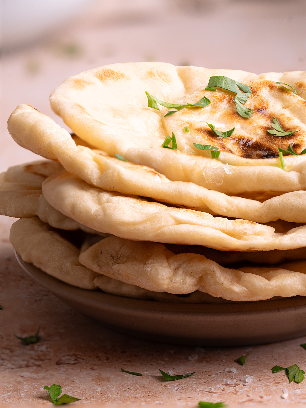 A plate stacked with pieces of sourdough discard naan bread