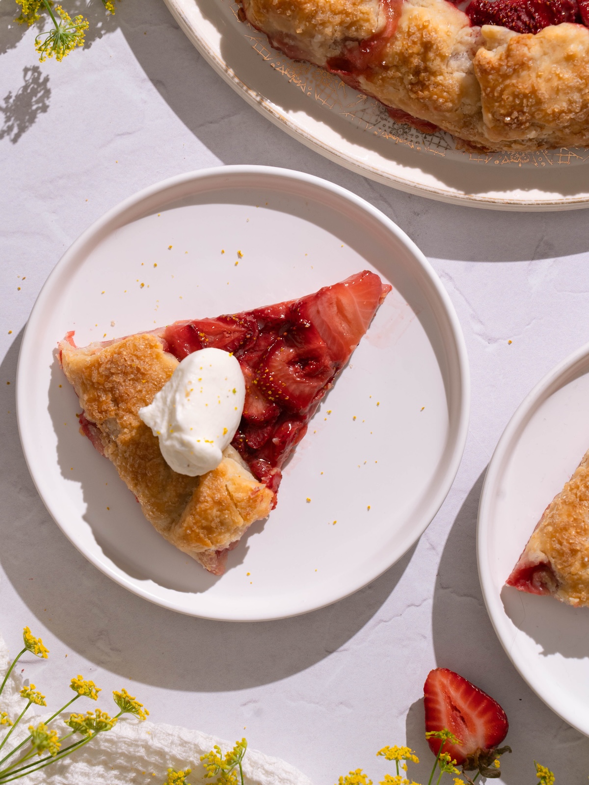 A slice of strawberry fennel pollen galette on a white plate