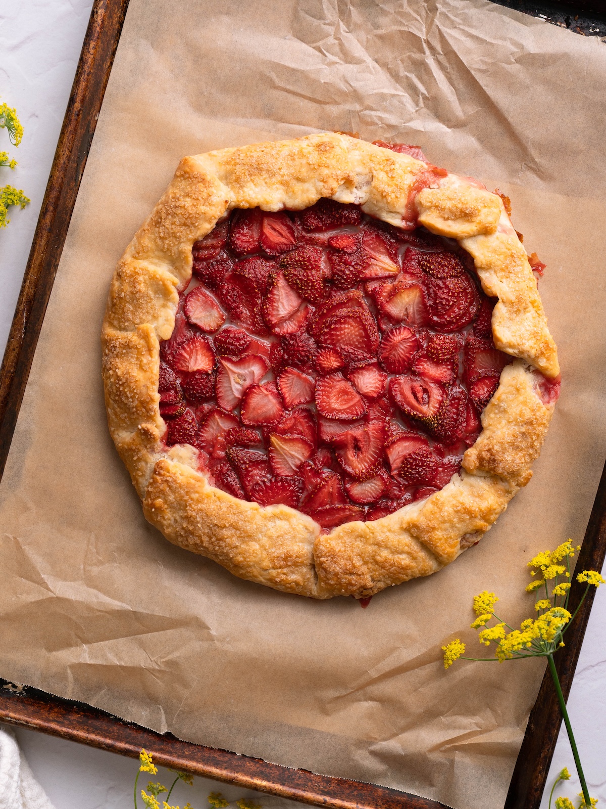 A baked strawberry galette on a baking sheet