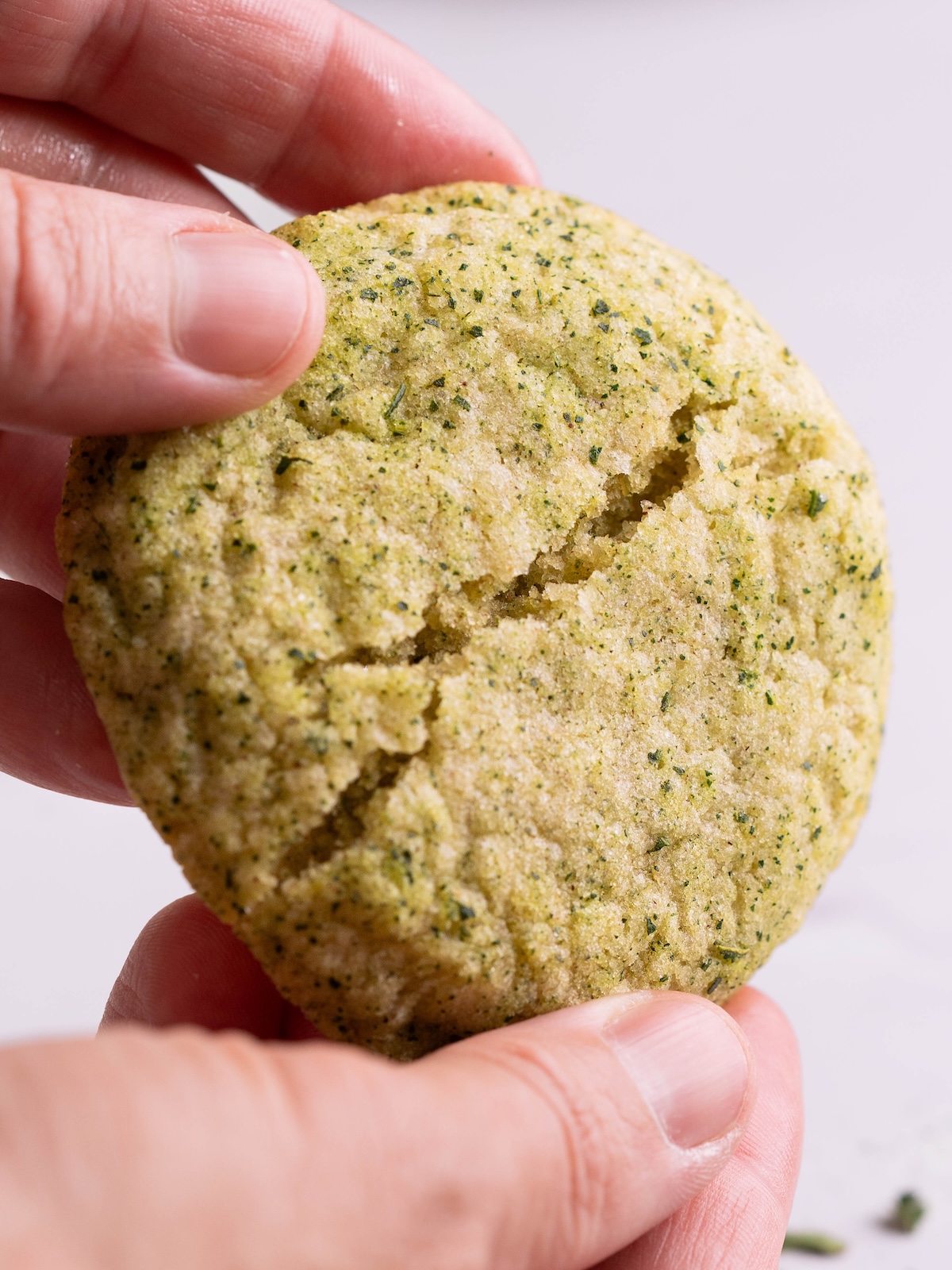 Hands breaking a fig leaf snickerdoodle in half