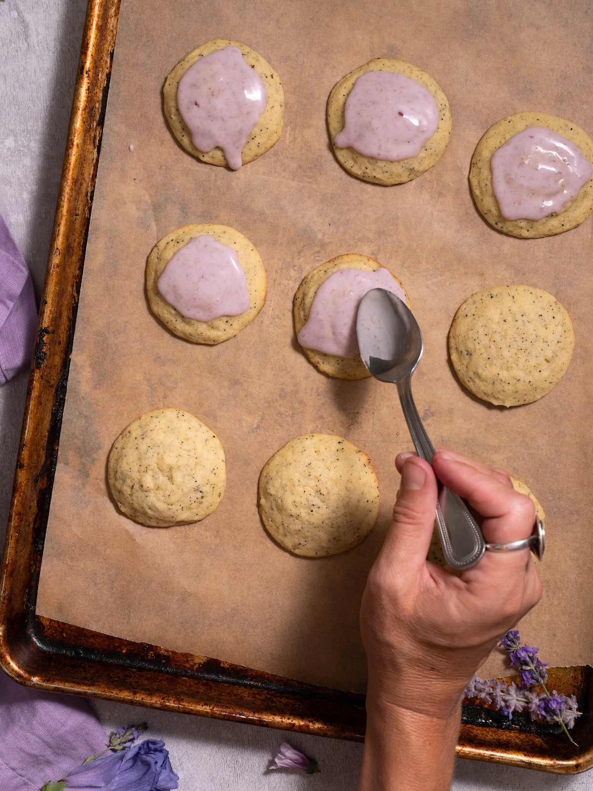 Spooning lavender glaze onto earl grey sugar cookies