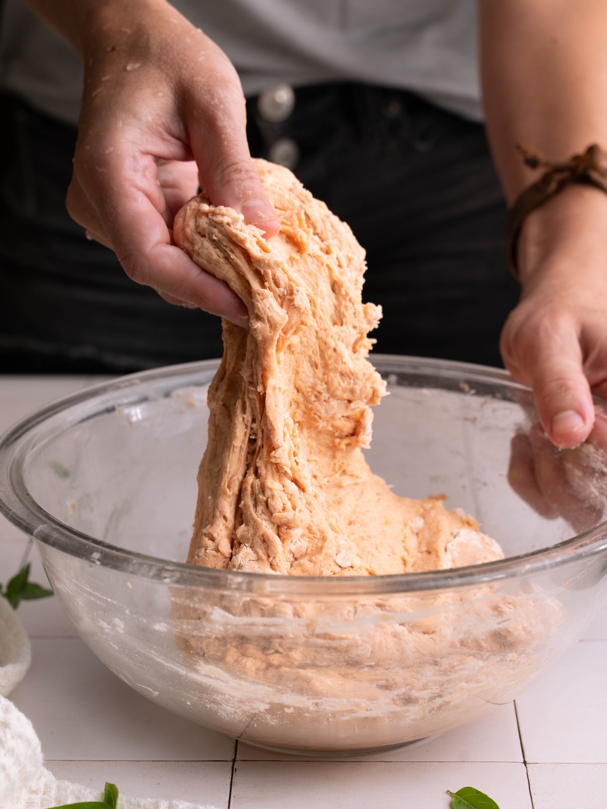 Hands stretching tomato sourdough