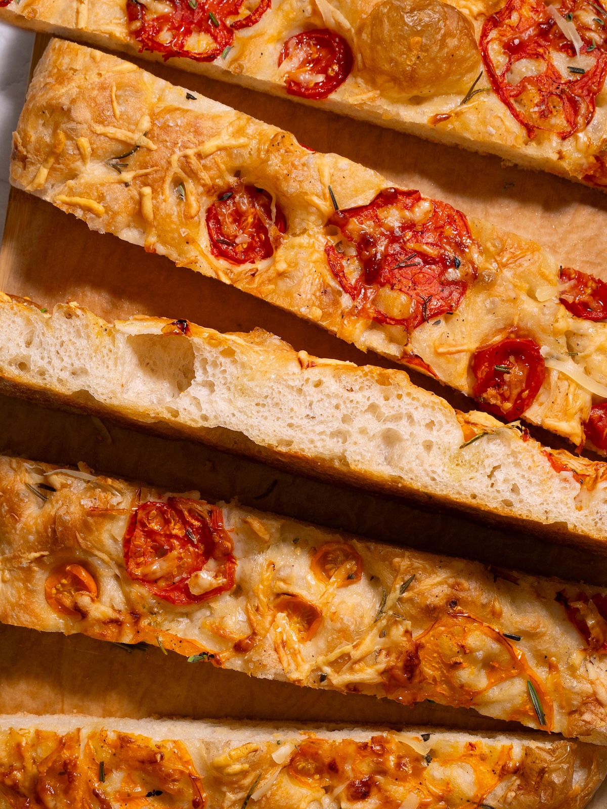 Slices of fresh tomato focaccia on a cutting board